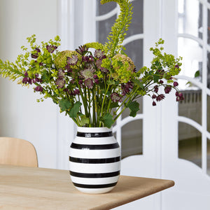 črno bela črtasta keramična vaza Omaggio Kahler s šopkom cvetja na mizi v interierju